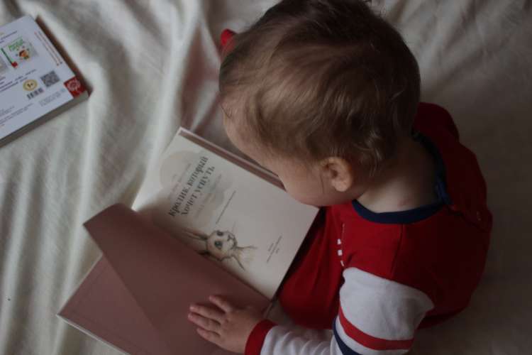 a young girl reading a picture book